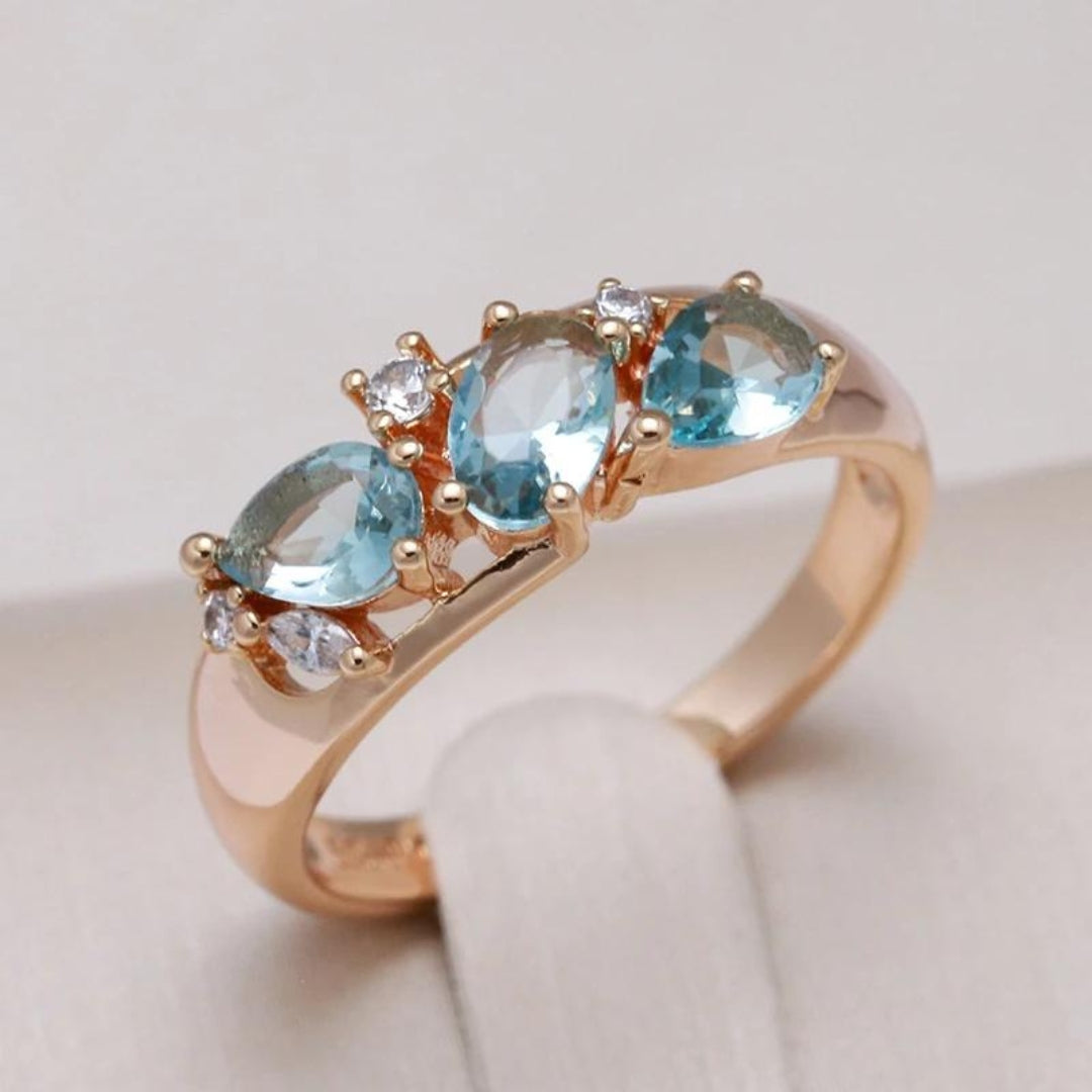 Bague vintage élégante bleue avec des pierres en zircon dans un sertissage doré.